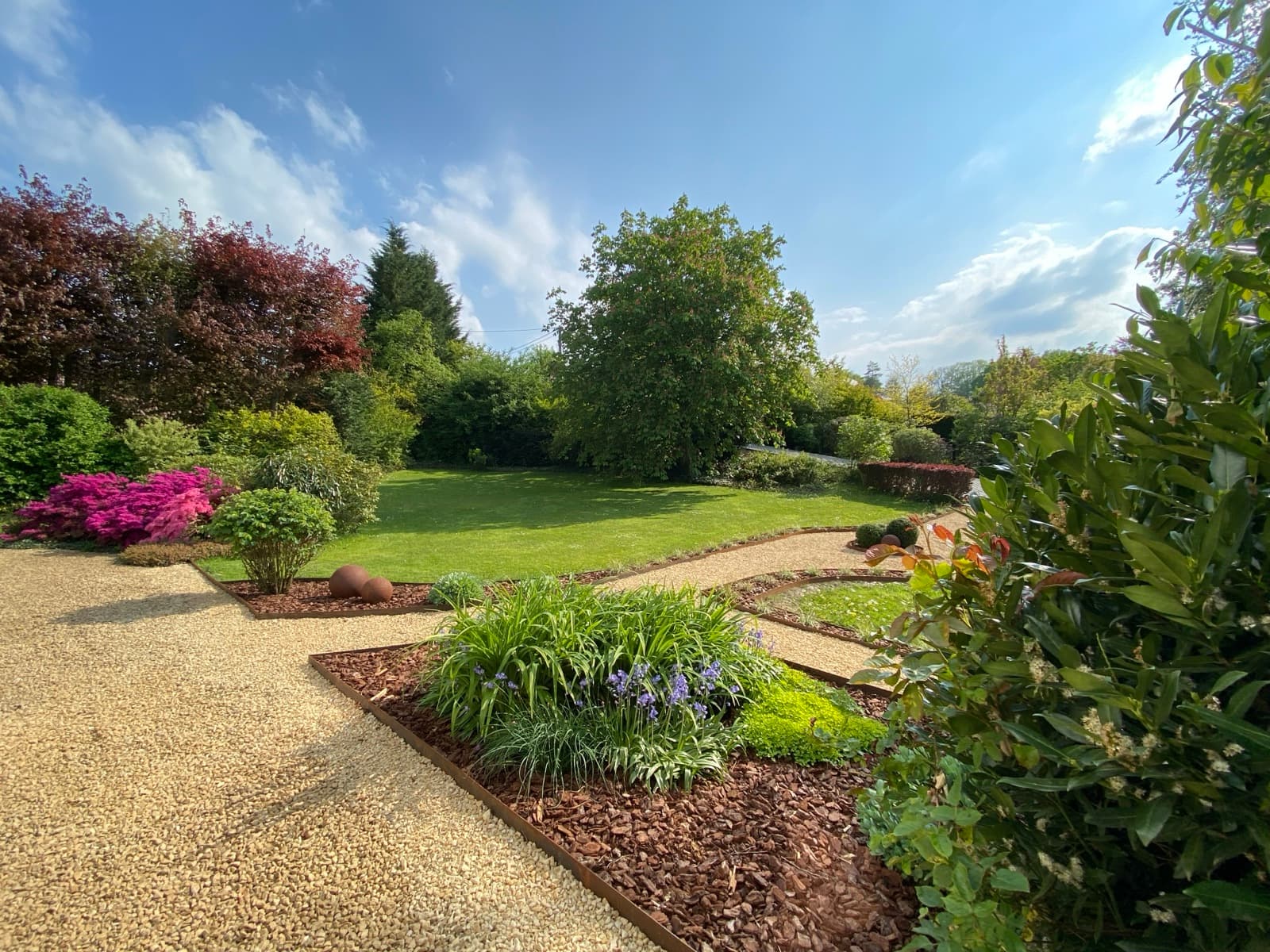 Jardin aménagé avec sentier corten et massifs fleuris