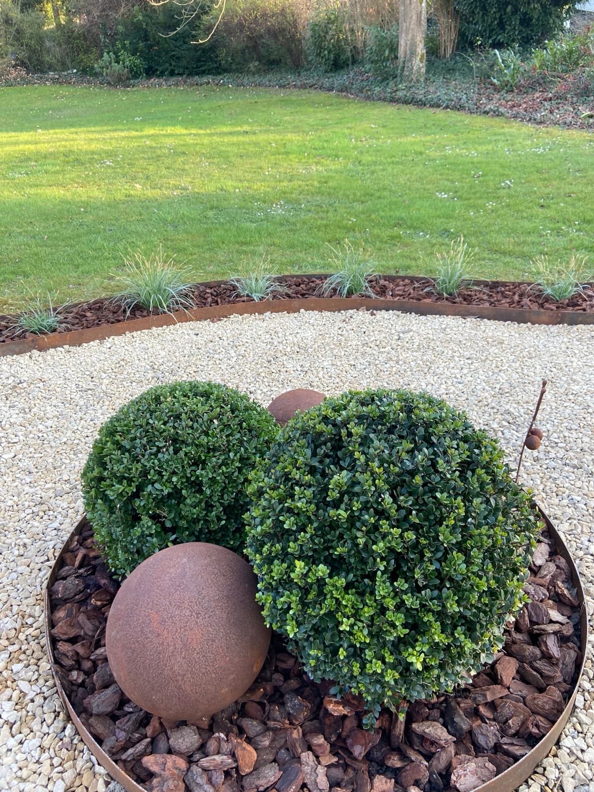 Sphère corten et buis taillés dans un jardin — Namur sud